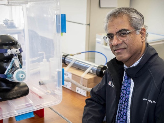 Dr. Sairam Parthasarathy sitting next to a health device.