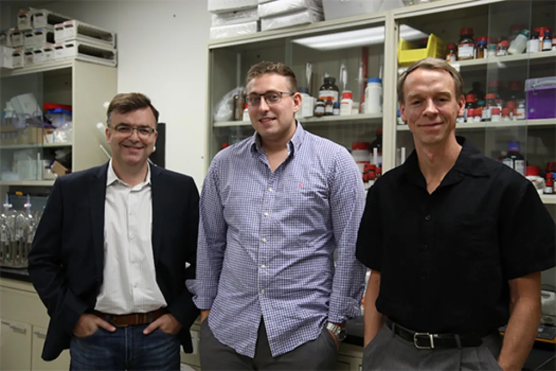 Three people posing for a picture in a lab setting