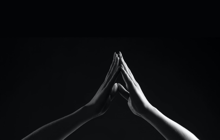 Black and white image of two hands touching 