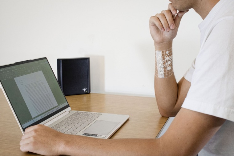 Man wearing wearable device for health at desk